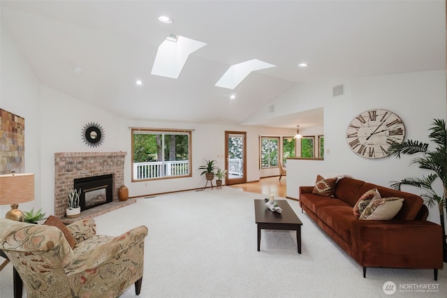 living area with lofted ceiling, light colored carpet, recessed lighting, a skylight, and a fireplace