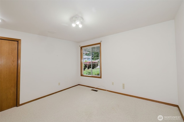 carpeted spare room featuring baseboards