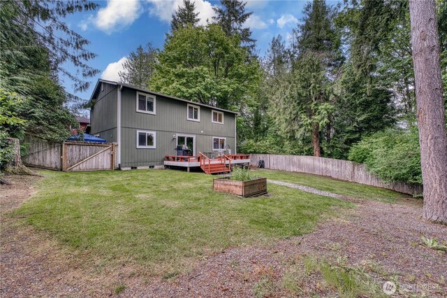 20282 NW Cedar Ln, Poulsbo, WA 98370 - back of property with a wooden deck, a garden, a gate, and crawl space