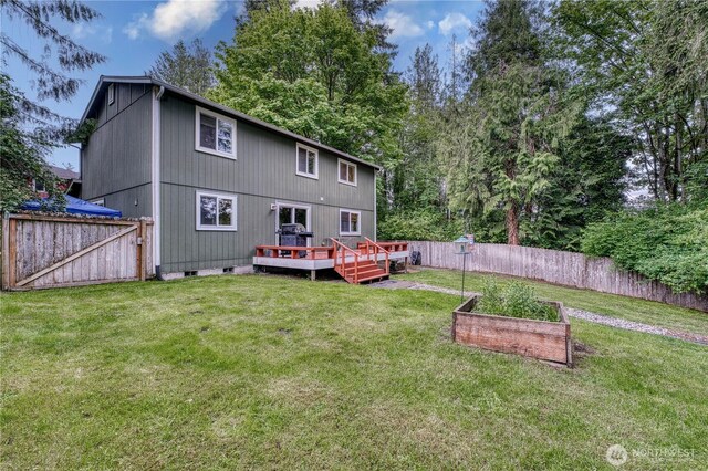 20282 NW Cedar Ln, Poulsbo, WA 98370 - back of property with a vegetable garden, a deck, crawl space, and a gate