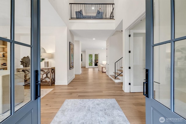 43268 SE 145th Pl, North Bend, WA 98045 - entryway featuring stairway, light wood-style floors, a towering ceiling, and baseboards
