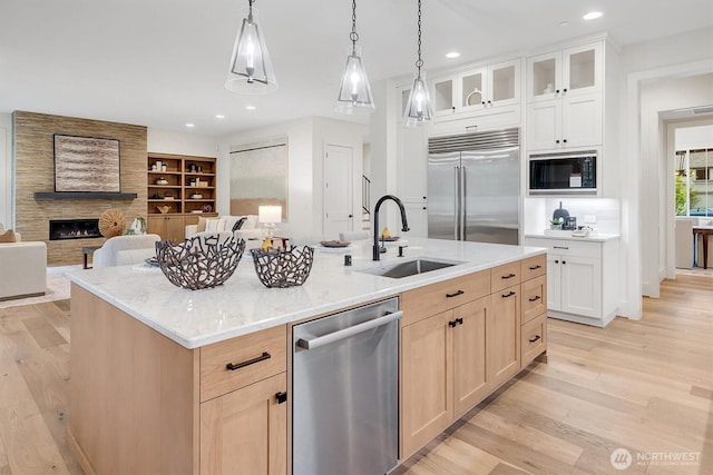 43268 SE 145th Pl, North Bend, WA 98045 - kitchen with built in appliances, a sink, light wood finished floors, a center island with sink, and glass insert cabinets