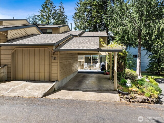 view of front of house with a shingled roof and concrete driveway