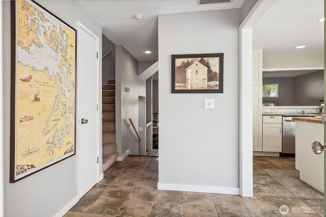corridor with stairs, baseboards, and recessed lighting