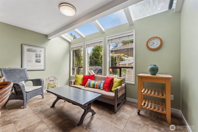 living room featuring a skylight and baseboards