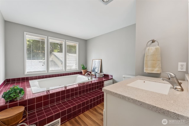 bathroom with a sink, a bath, and wood finished floors