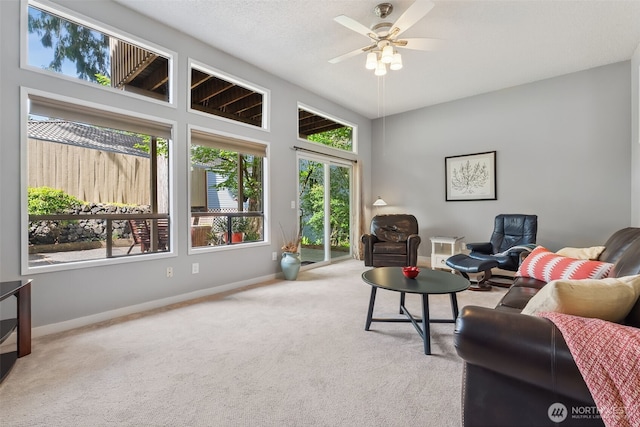 living area with carpet flooring, baseboards, and ceiling fan