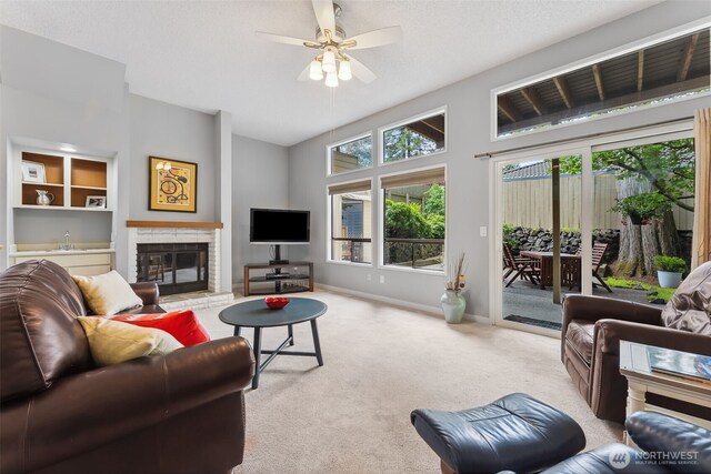 carpeted living room with a brick fireplace, ceiling fan, a sink, baseboards, and vaulted ceiling
