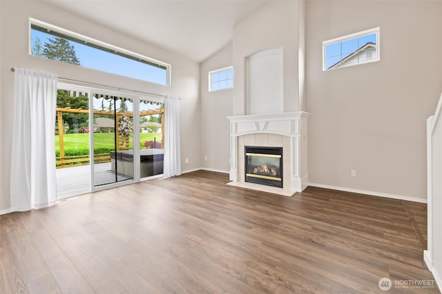 7521 Sterling Pl, Arlington, WA 98223 - unfurnished living room with high vaulted ceiling, a tile fireplace, wood finished floors, and baseboards