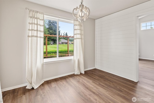 7521 Sterling Pl, Arlington, WA 98223 - unfurnished dining area with wood finished floors, baseboards, and a chandelier