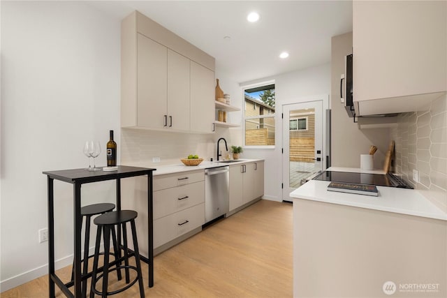 1523 N 39th St, Seattle, WA 98103 - kitchen with appliances with stainless steel finishes, backsplash, light wood-style flooring, light countertops, and recessed lighting