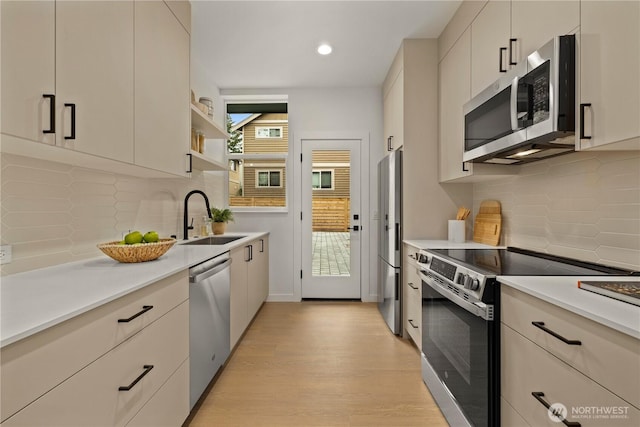 1523 N 39th St, Seattle, WA 98103 - kitchen featuring appliances with stainless steel finishes, light countertops, light wood-style floors, tasteful backsplash, and recessed lighting