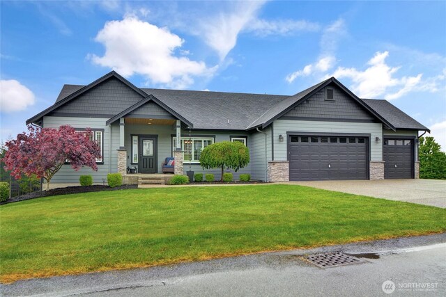 craftsman inspired home with an attached garage, driveway, a front yard, stone siding, and a shingled roof