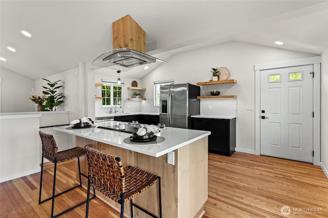 21 Hexon Rd, Selah, WA 98942 - kitchen with stainless steel fridge, open shelves, vaulted ceiling, a kitchen breakfast bar, and light wood-style floors