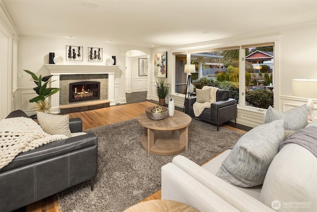 2249 78th Ave SE, Mercer Island, WA 98040 - living room with arched walkways, wood finished floors, a lit fireplace, a decorative wall, and wainscoting