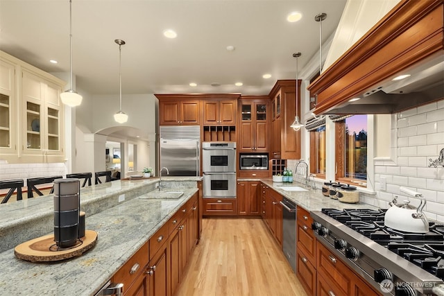 2249 78th Ave SE, Mercer Island, WA 98040 - kitchen with a sink, built in appliances, arched walkways, custom exhaust hood, and decorative backsplash