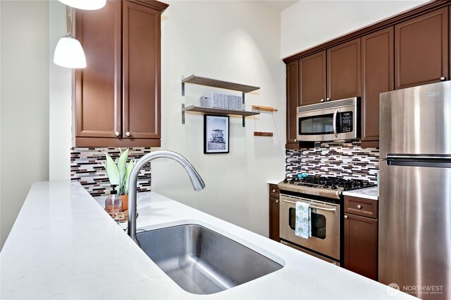 400 Washington Ave Unit 415, Bremerton, WA 98337 - kitchen featuring appliances with stainless steel finishes, a sink, backsplash, and light countertops