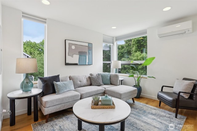 living area with a wall mounted air conditioner, healthy amount of natural light, wood finished floors, and recessed lighting