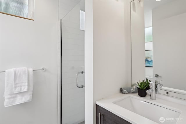 bathroom featuring a shower stall and vanity