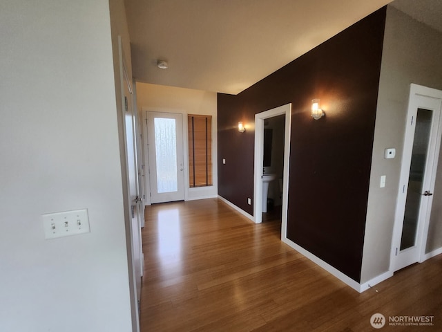 hallway with wood finished floors and baseboards