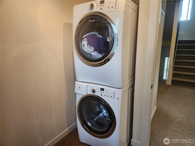laundry room with stacked washer and clothes dryer, baseboards, and dark colored carpet
