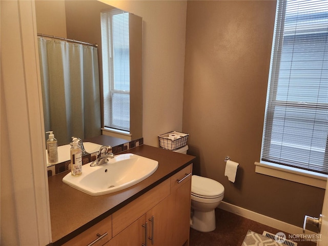 bathroom featuring vanity, toilet, a shower with curtain, and baseboards