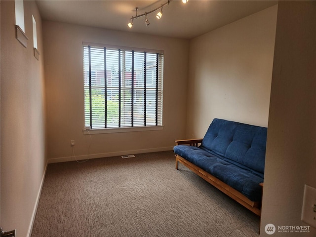 sitting room featuring baseboards, carpet flooring, and rail lighting