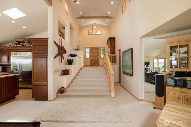 foyer entrance with light carpet, recessed lighting, baseboards, high vaulted ceiling, and stairs