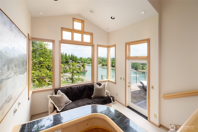 sunroom / solarium featuring vaulted ceiling and a water view