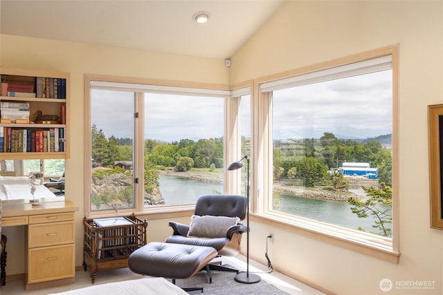sitting room featuring lofted ceiling, a water view, and plenty of natural light