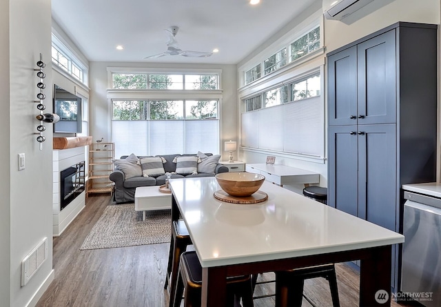 990 Lake Whatcom Blvd Unit 11, Sedro Woolley, WA 98284 - kitchen featuring wood finished floors, a ceiling fan, a glass covered fireplace, light countertops, and recessed lighting