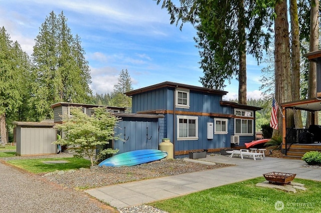 990 Lake Whatcom Blvd Unit 11, Sedro Woolley, WA 98284 - back of property with board and batten siding, a patio area, an outdoor fire pit, an outdoor structure, and a shed
