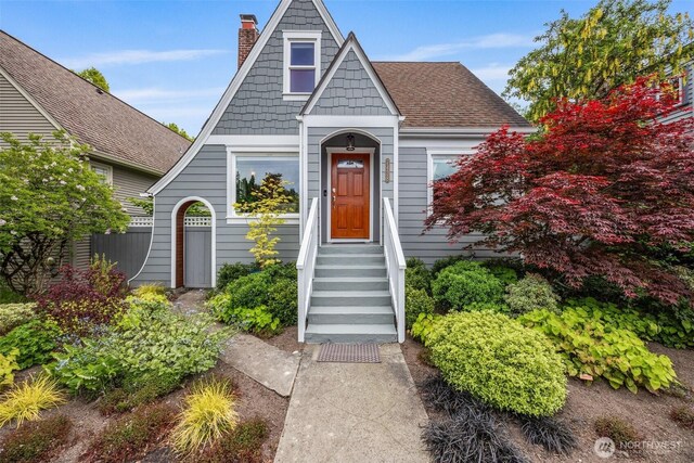 view of front of property featuring a shingled roof and a chimney