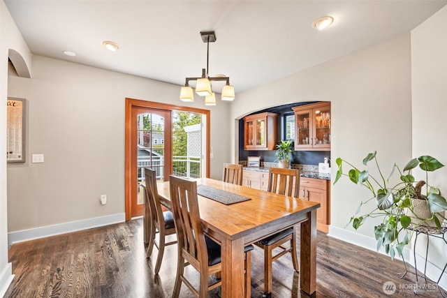 dining area with baseboards and dark wood finished floors