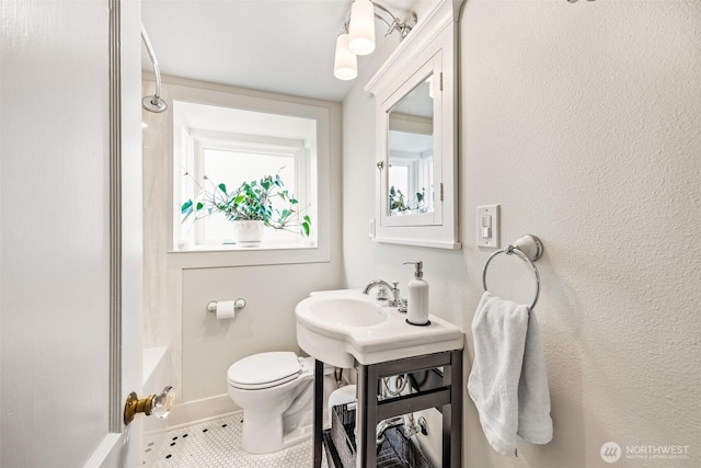 bathroom with toilet, tile patterned flooring, a shower, and baseboards