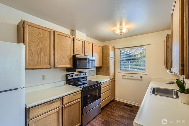 4105 Providence Point Dr SE, Issaquah, WA 98029 - kitchen with stainless steel appliances, a sink, light countertops, dark wood-type flooring, and baseboards