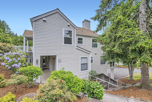 4105 Providence Point Dr SE, Issaquah, WA 98029 - view of front of home with a shingled roof, a chimney, and a patio