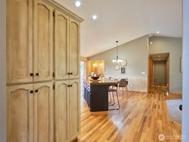 13708 401st Way, Amboy, WA 98601 - kitchen with lofted ceiling, light wood finished floors, a wainscoted wall, a breakfast bar, and decorative light fixtures