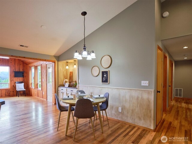 13708 401st Way, Amboy, WA 98601 - dining room with wood finished floors, wooden walls, high vaulted ceiling, a chandelier, and baseboards