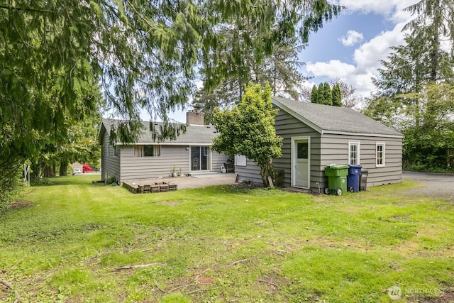 3822 Shelby Rd, Lynnwood, WA 98087 - rear view of house featuring a patio, a lawn, a chimney, and a shingled roof