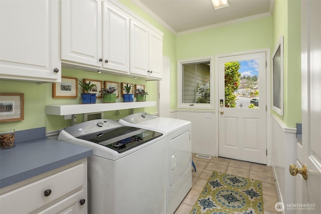 laundry room with cabinet space, washing machine and clothes dryer, light tile patterned floors, and crown molding