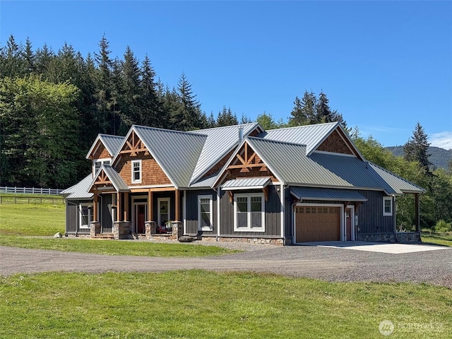 921 Chicken Coop Rd, Sequim, WA 98382 - view of front of house featuring board and batten siding, a garage, gravel driveway, metal roof, and covered porch