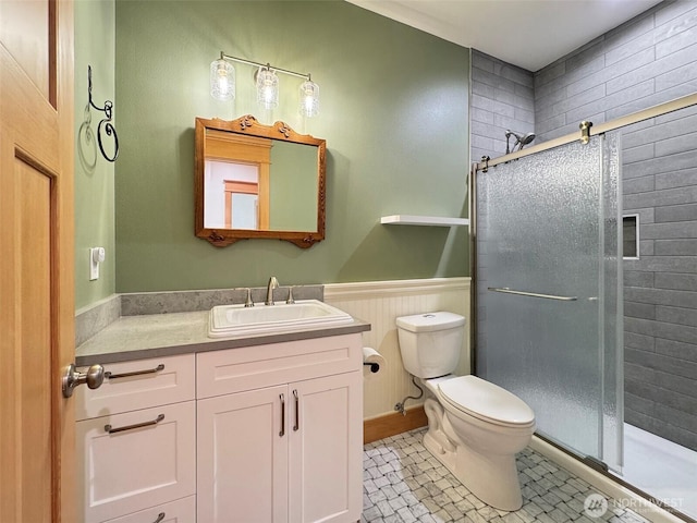921 Chicken Coop Rd, Sequim, WA 98382 - bathroom with a shower stall, toilet, vanity, a wainscoted wall, and tile patterned floors
