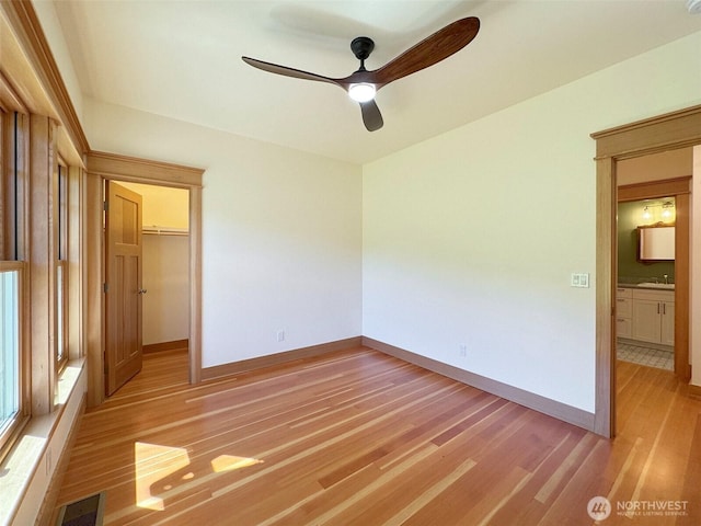 921 Chicken Coop Rd, Sequim, WA 98382 - unfurnished bedroom featuring light wood-style floors, a sink, baseboards, a spacious closet, and a closet