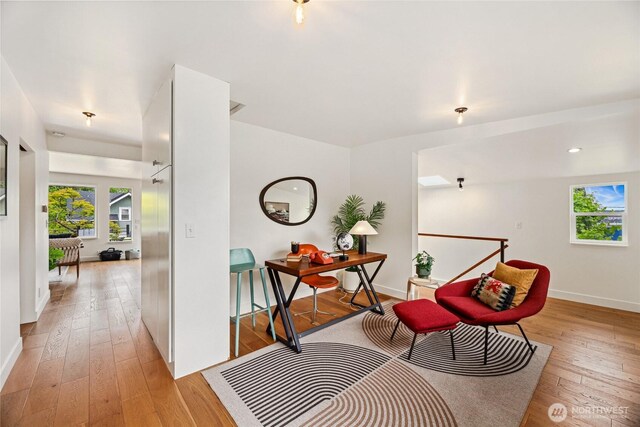 living area featuring light wood-style floors, baseboards, and recessed lighting