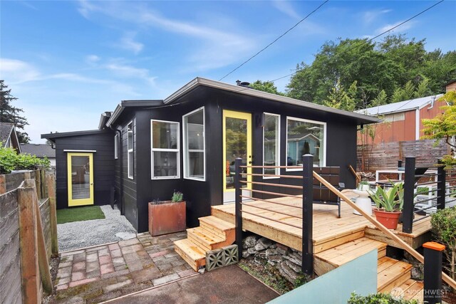 rear view of property with fence and a wooden deck