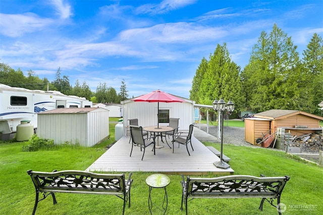 316 W Lake Samish Dr, Bellingham, WA 98229 - view of green lawn featuring a storage shed, an outbuilding, outdoor dining space, and a wooden deck