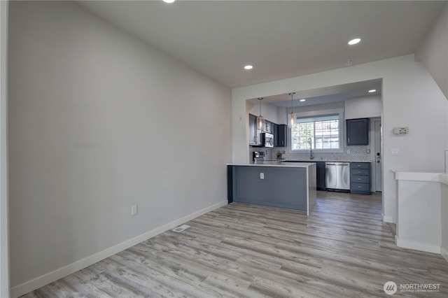 23120 SE Black Nugget Rd Unit A2, Issaquah, WA 98029 - kitchen with appliances with stainless steel finishes, recessed lighting, a peninsula, light wood-style flooring, and tasteful backsplash