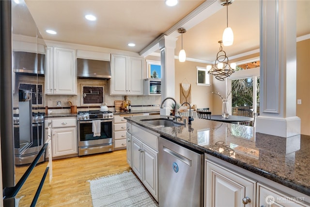 3212 Maplewood Cir NE, Tacoma, WA 98422 - kitchen with appliances with stainless steel finishes, range hood, white cabinets, backsplash, and light wood-type flooring