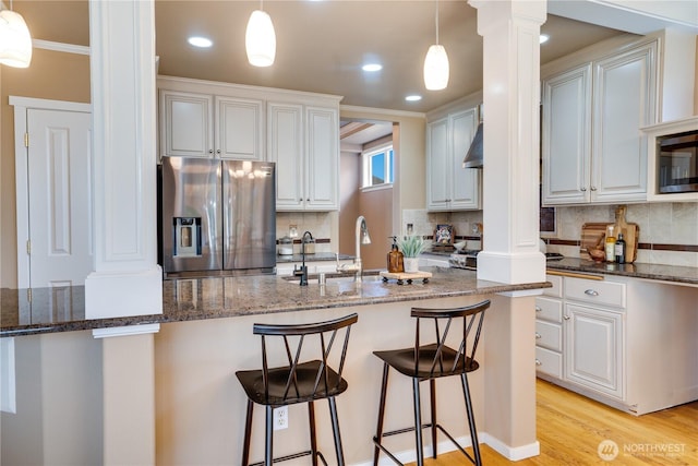 3212 Maplewood Cir NE, Tacoma, WA 98422 - kitchen with decorative columns, appliances with stainless steel finishes, decorative backsplash, dark stone countertops, and ornamental molding